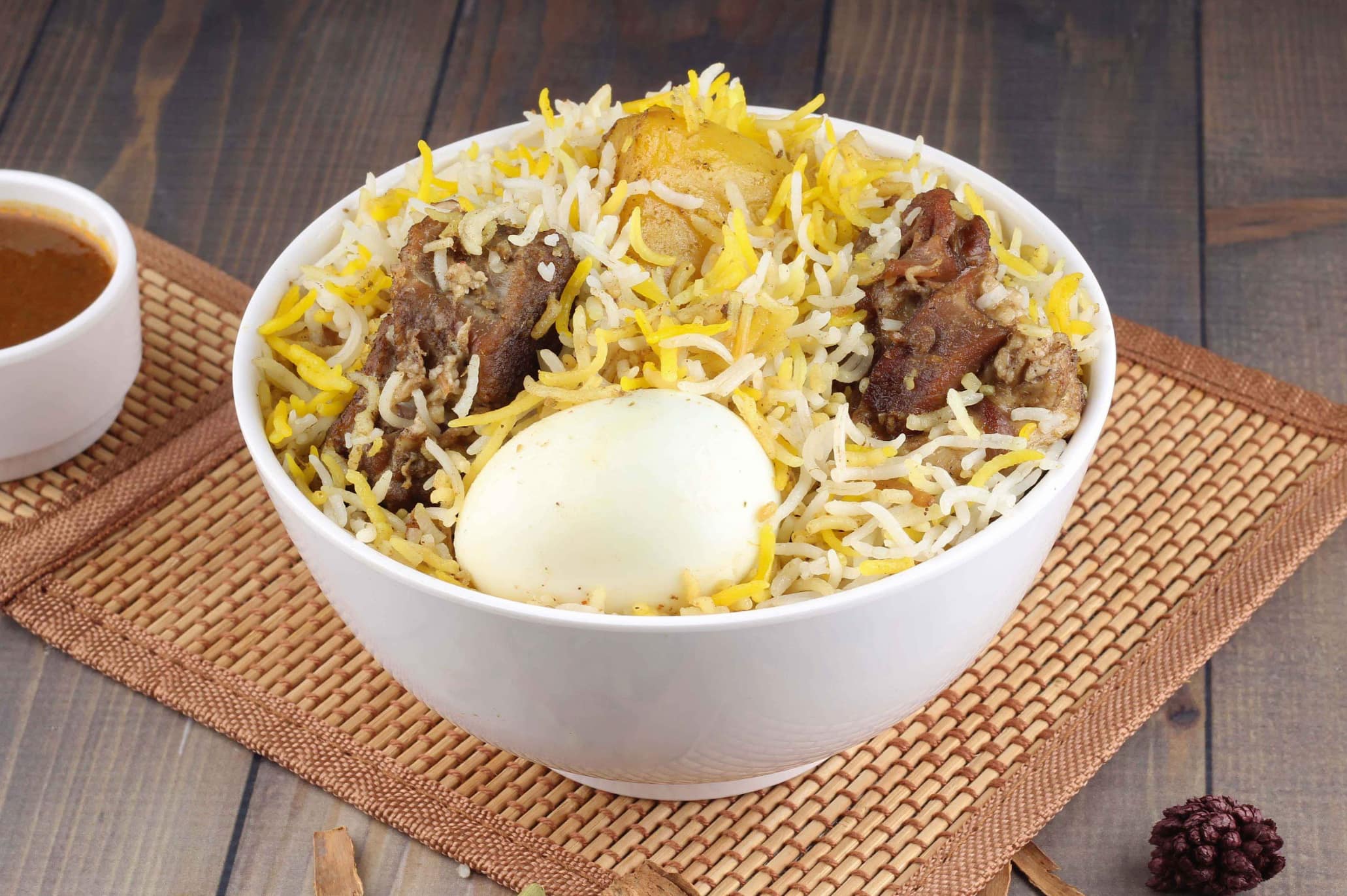 A bowl of Malabar biryani topped with egg and slow-cooked meat